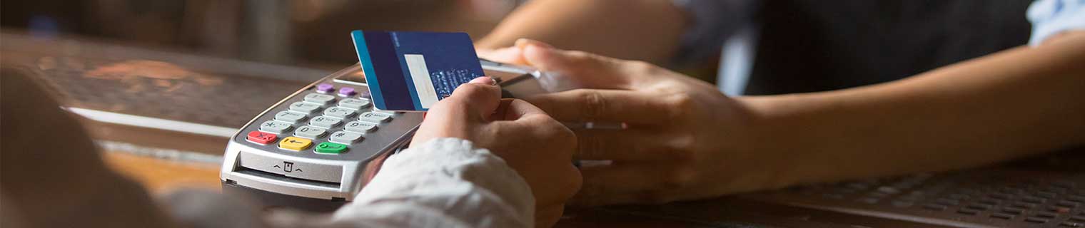 Person using credit card with a card reader.